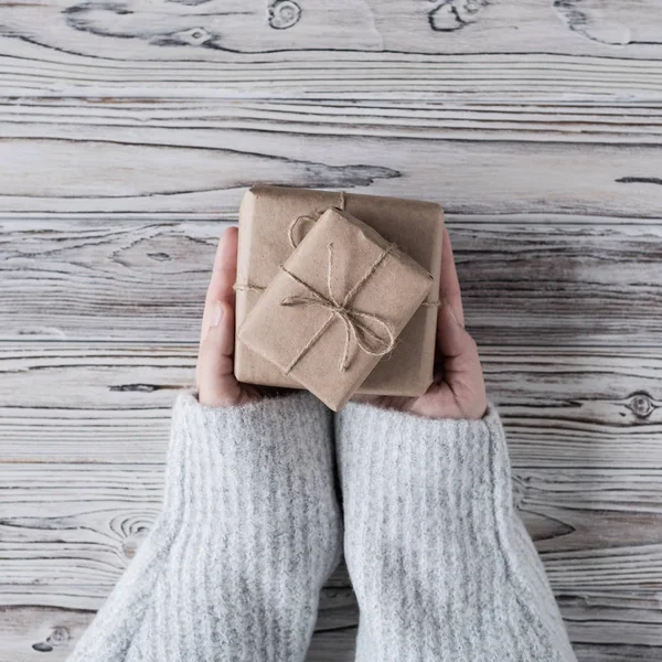 女性包装礼物 纸板箱在工艺纸 圣诞绳和树在乡村木板的背景 — 图库照片