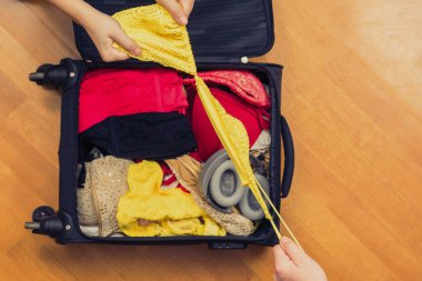 Bir erkek eli mayo için bir bavula bikini koymaya izin vermez. Kavram