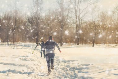 Kışın kar yağarken parkta kayak yapan gençlerin dikiz görüntüsü