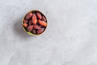 Gri beton bir arka planda Hindistan cevizi kasesinin içindeki kraliyet meyveleri.. 