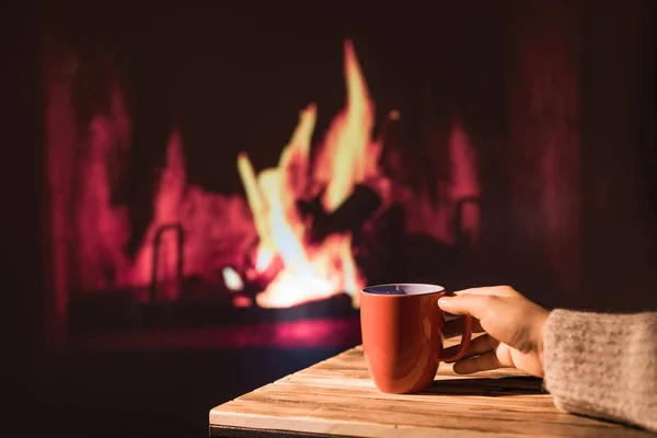 Vrouw Een Wintertrui Ontspant Zich Bij Kersthaard Met Een Kopje — Stockfoto