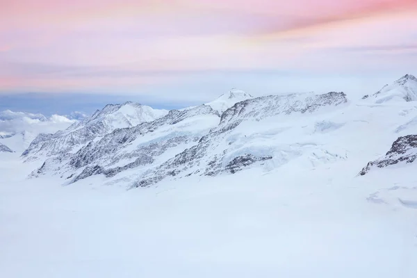 スイスのパステルカラーの夕日の空を背景に ベルネーゼ アルプスのJungfru山の雪のサミット — ストック写真