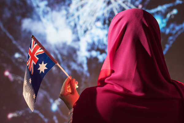 Muslim woman in a scarf holding Australian flag during fireworks at night. — Stock Image Muslim Woman Scarf Holding Australian Flag Fireworks Night Royalty Free Stock Images