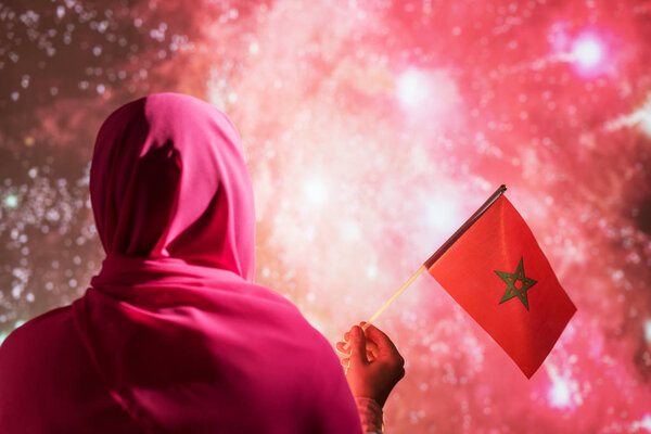 Muslim woman in a scarf holding flag of Morocco during fireworks at night. — Stock Image Muslim Woman Scarf Holding Flag Morocco Fireworks Night Royalty Free Stock Images
