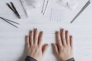 The process of putting artificial (fake) fingernail on the finger. Woman manicure. Flat lay.