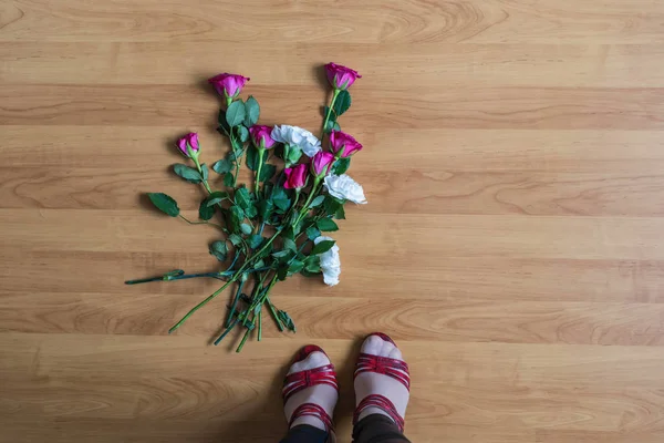 woman standing on the floor among scattered flowers. Broken relationships in bad Valentine\'s day. concept.