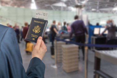 Amerikan pasaportu taşıyan mavi takım elbiseli bir adam havaalanında gümrük kontrolü ya da güvenlik teşkilatının karşısında. konsept. 