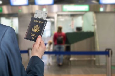 Göçmenlik ve pasaport kontrolünün karşısındaki havaalanında pasaportu olan mavi takım elbiseli bir adam. konsept. Amerika. Usa
