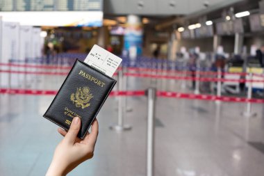 Havaalanının karşısındaki giriş alanında Amerikan pasaportlu bir kadın el ele tutuşuyor. konsept. Amerika. Usa