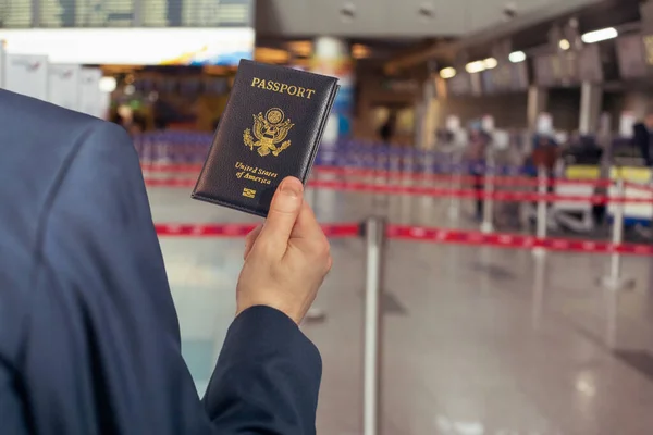 Άντρας Επιχειρηματίας Μπλε Κοστούμι Κρατώντας Αμερικανικό Διαβατήριο Στις Κυλιόμενες Σκάλες — Φωτογραφία Αρχείου