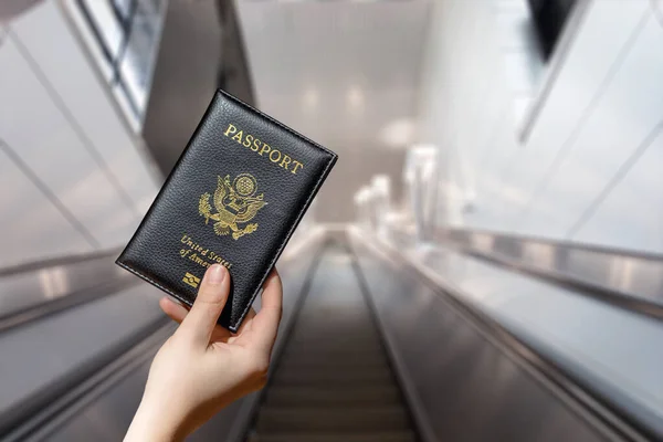 Kvinna Hand Med Amerikanskt Pass Flygplatsen Rulltrappa — Stockfoto