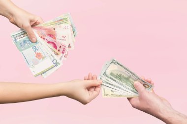 Pembe arka planda para değiş tokuşu yapan kadınlar