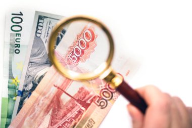 Beş bin Rus rublesi büyüteç altında Avro ve Amerikan dolarının üzerinde. Ana uluslararası para birimi kavramı