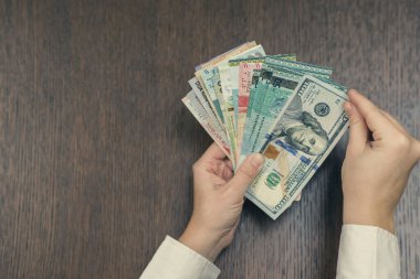 Kadın elinde bir sürü para tutuyor.