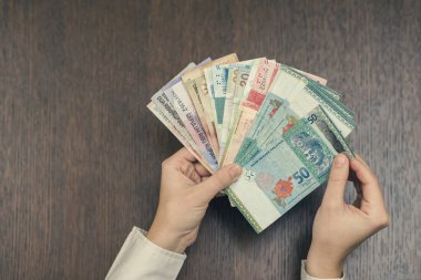 Kadın elinde bir sürü para tutuyor.