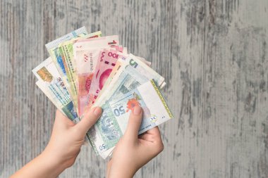 Kadın elleri tahtadan arka planda para banknotlarını tutuyor.