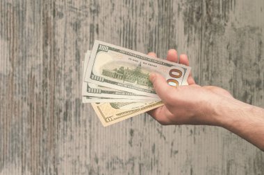 Kadın elleri tahtadan arka planda para banknotlarını tutuyor.