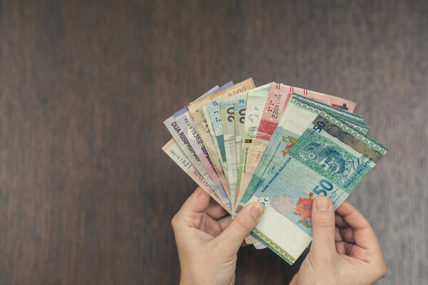 woman holding various money bills
