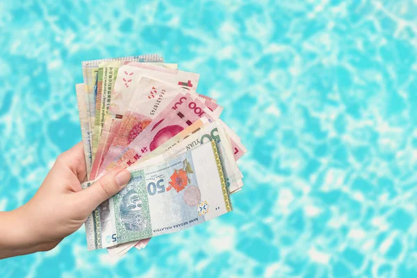 female hands holding money bills over blue background