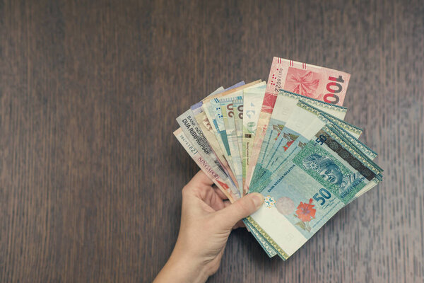woman holding various money bills