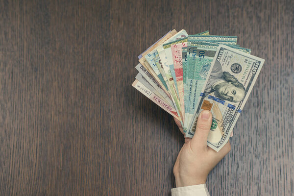 woman holding various money bills