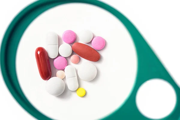 Pillole Sotto Una Lente Ingrandimento Sullo Sfondo Bianco Prove Verifiche — Foto Stock