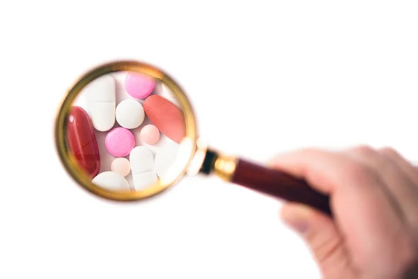 Pillole Sotto Una Lente Ingrandimento Sullo Sfondo Bianco Prove Verifiche — Foto Stock