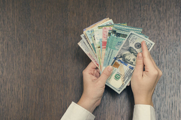 woman holding various money bills