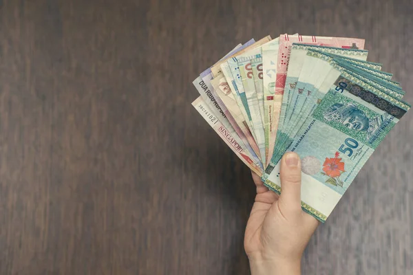 woman holding various money bills