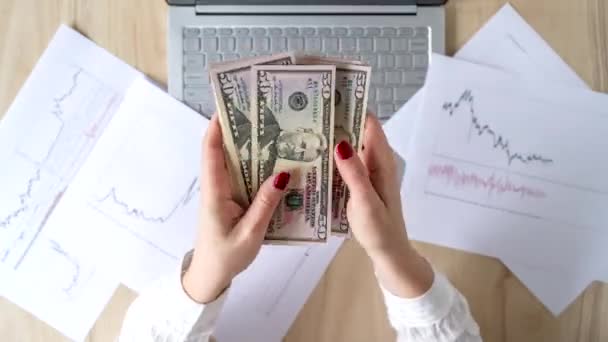 女性フリーランサーは50ドルの銀行券を手に入れ 収入を数える ノートパソコンにグラフィックとチャートが印刷されています 外国為替だ — ストック動画