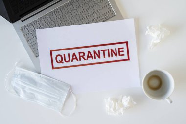 Coronavirus ve karantina yüzünden ofiste hasta bir çalışanın terkedilmiş işyeri. Tıbbi maske, peçete ve bir fincan bitmiş kahve ile birlikte. Dünya çapında salgın konsepti