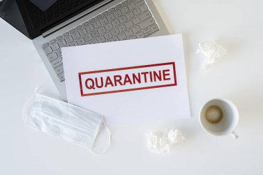 Coronavirus ve karantina yüzünden ofiste hasta bir çalışanın terkedilmiş işyeri. Tıbbi maske, peçete ve bir fincan bitmiş kahve ile birlikte. Dünya çapında salgın konsepti
