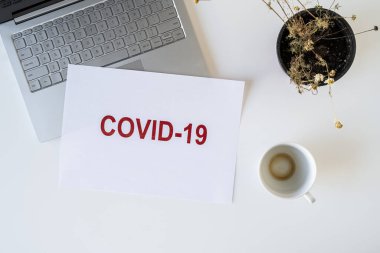 Coronavirüs ve karantina yüzünden ofiste hasta bir çalışanın terk edilmiş işyeri ve bir fincan kahve. Dünya çapında salgın konsepti