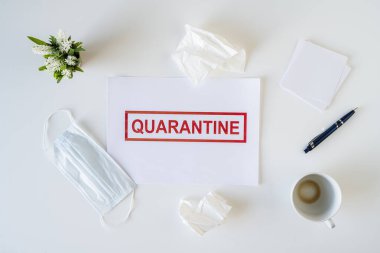 Coronavirus ve karantina yüzünden ofiste hasta bir çalışanın terkedilmiş işyeri. Tıbbi maske, peçete ve bir fincan bitmiş kahve ile birlikte. Dünya çapında salgın konsepti
