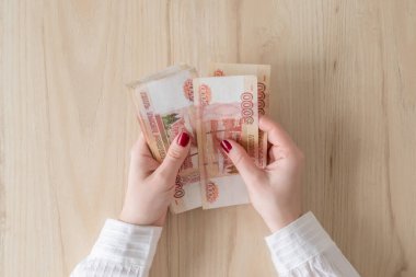 Kadın elinde beş bin ruble tutuyor ve sayıyor. Para değişimi. Banka operasyonu. Finans hizmetleri. Finansal piyasa. Döviz değişimi noktası. Kavram. Düz yatıyordu