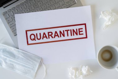 Coronavirus ve karantina yüzünden ofiste hasta bir çalışanın terkedilmiş işyeri. Tıbbi maske, peçete ve bir fincan bitmiş kahve ile birlikte. Dünya çapında salgın konsepti