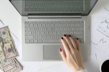 Kadın banknot paketini elinde tutan serbest çalışan elli Amerikan doları ve kârı ve geliri de sayıyor. Ofis masasındaki kağıda grafikler ve çizelgeler basılmış. Eski bir takas. Düz yatıyordu