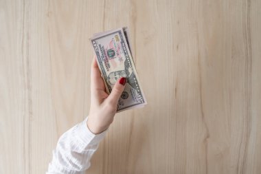Kadın 50 Amerikan dolarını elinde tutuyor ve sayıyor. Para değişimi. Banka operasyonu. Finans hizmetleri. Finansal piyasa. Döviz değişimi noktası. Kavram. Düz yatıyordu