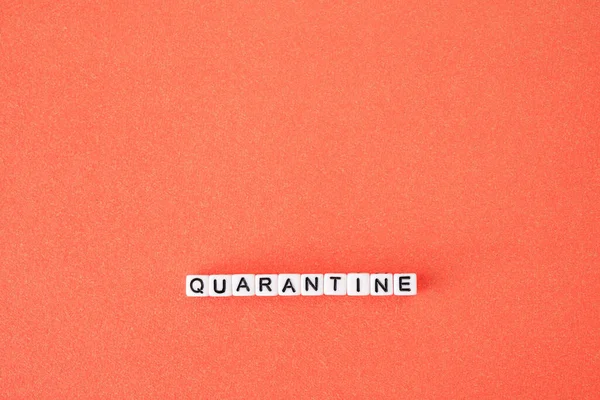 The word quarantine on red background. Worldwide pandemic concept, production and work shutdown