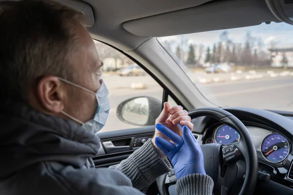 医療マスクの男は 車を運転しながら細菌やウイルスから身を守るためにゴム手袋を着用しています コロナウイルス パンデミック — ストック写真