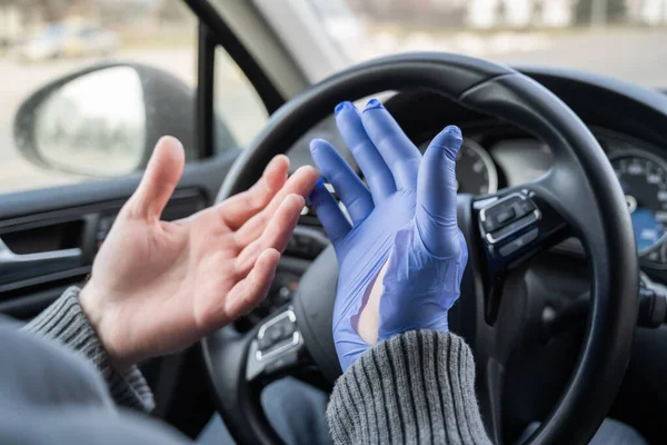 車を運転している間人は細菌およびウイルスから身を守るためにゴム手袋をつける コロナウイルス パンデミック — ストック写真