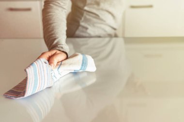 Kadın mutfak masasındaki bir bezle temizleme bezi. Oda servisi mi? Dezenfeksiyon kavramı. Virüs ve bakterilerden korunma