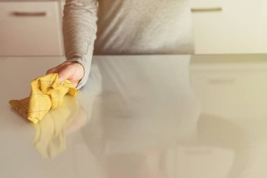 Kadın mutfak masasındaki bir bezle temizleme bezi. Oda servisi mi? Dezenfeksiyon kavramı. Virüs ve bakterilerden korunma