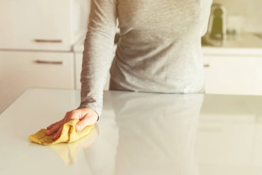 Kadın mutfak masasındaki bir bezle temizleme bezi. Oda servisi mi? Dezenfeksiyon kavramı. Virüs ve bakterilerden korunma