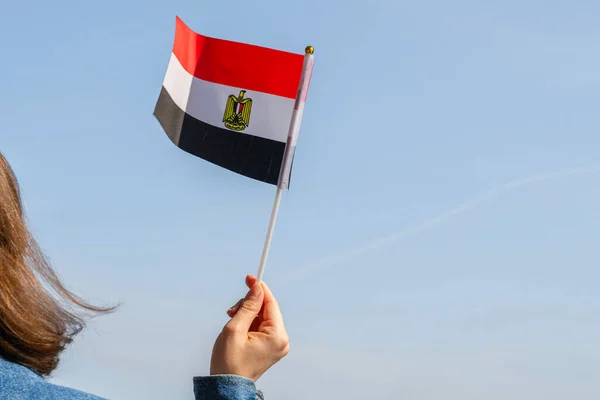 Muslim woman with Egyptian flag on the blue sky. Egyptian. Concept