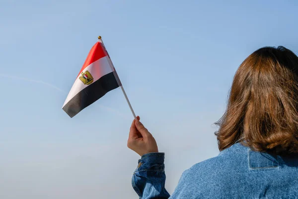 Muslim woman with Egyptian flag on the blue sky. Egyptian. Concept