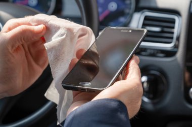 Mavi takım elbiseli orta yaşlı işadamı kendini bakteri ve virüsten korumak için antivirüs antibakteriyel ıslak mendil (peçete) kullanıyor.. 