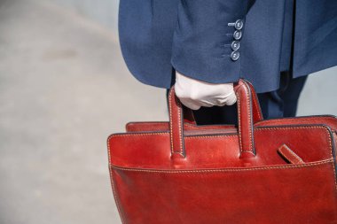 Şehir caddesinde yaya geçidinde mavi takım elbiseli ve koruyucu beyaz eldivenli yalnız bir işadamı. Virüslere, mikroplara ve bakterilere karşı sağlık koruması. Coronavirüs