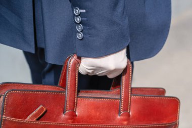 Şehir caddesinde yaya geçidinde mavi takım elbiseli ve koruyucu beyaz eldivenli yalnız bir işadamı. Virüslere, mikroplara ve bakterilere karşı sağlık koruması. Coronavirüs