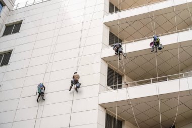 Yüksek katlı pencereler ve binalar temizleyici. Coronavirüs veya Covid-19 'un ortaya çıkmasından dolayı sokak binası dezenfekte ve sterilizasyon.
